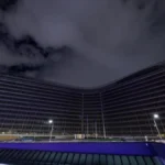 A dramatic night view of the European Commission Berlaymont building in Brussels, reflecting the opaque corporate lobbying surrounding the EU AI Act.
