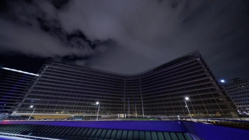 A dramatic night view of the European Commission Berlaymont building in Brussels, reflecting the opaque corporate lobbying surrounding the EU AI Act.