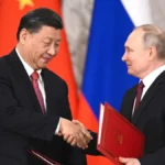 Vladimir Putin and Xi Jinping shake hands during a Russia-China bilateral signing ceremony