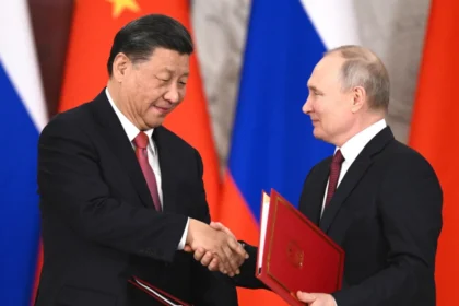 Vladimir Putin and Xi Jinping shake hands during a Russia-China bilateral signing ceremony