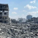Destroyed residential buildings in Gaza City's Rimal neighbourhood following an Israeli airstrike, illustrating the scale of civilian infrastructure damage across Gaza
