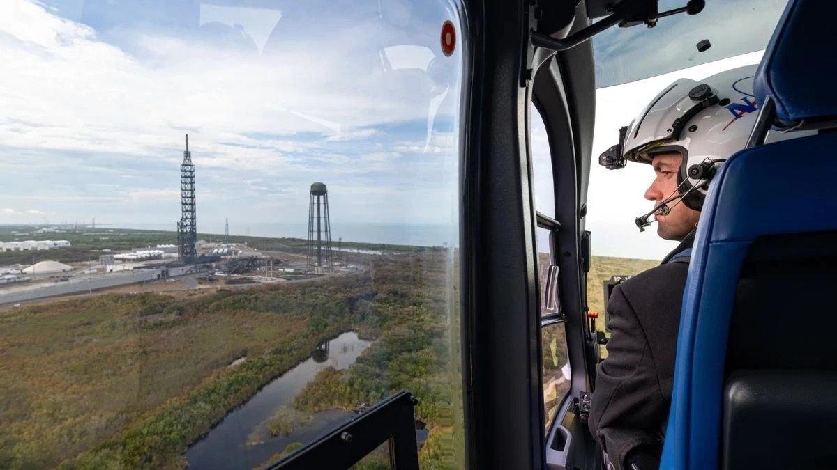 NASA Administrator Jared Isaacman looking out of a helicopter window at the destroyed Blue Origin Launch Complex 36 after the New Glenn rocket explosion.