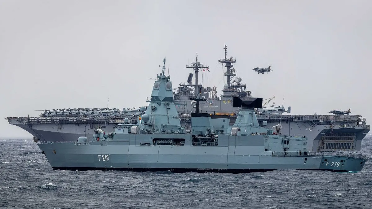 US Navy amphibious assault ship USS Kearsarge underway at sea alongside the German frigate Sachsen